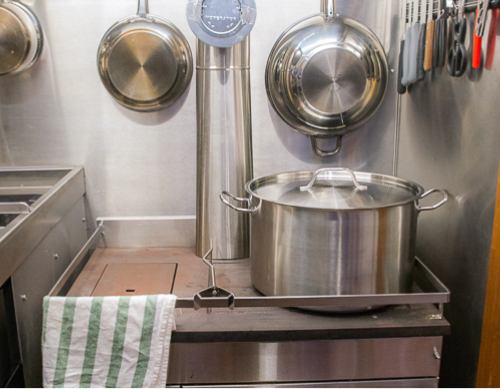 Dans le prolongement des tables, se trouve l’antre de notre Second: la cuisine!  Vous avez envie de montrer vos talents culinaires ou de donner un petit coup de main? Pas de soucis, la convivialité est le maître mot de l'équipage, notre chef cuisinier deviendra votre commis!